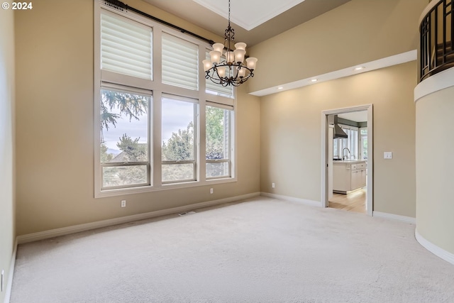 carpeted spare room featuring sink and a chandelier