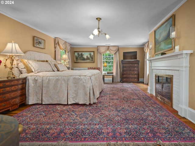 bedroom with wood-type flooring, a fireplace, a chandelier, and crown molding