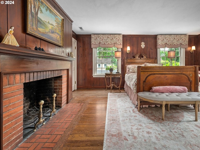 bedroom with a fireplace and wood walls