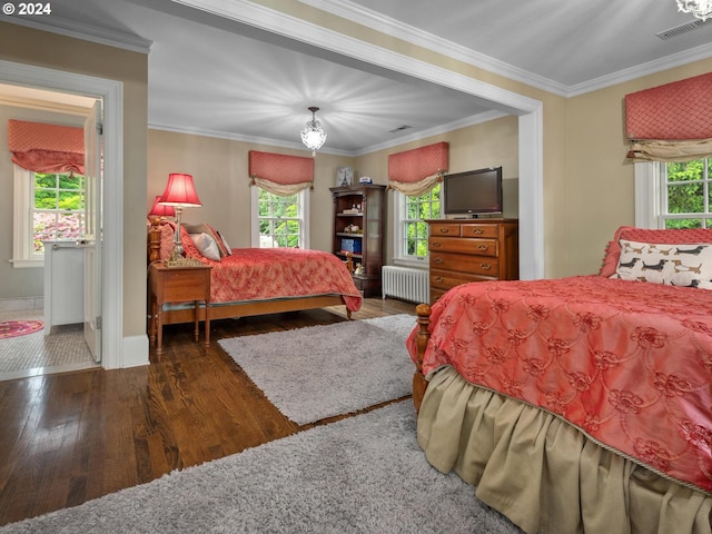 bedroom with dark hardwood / wood-style flooring, radiator heating unit, multiple windows, and crown molding