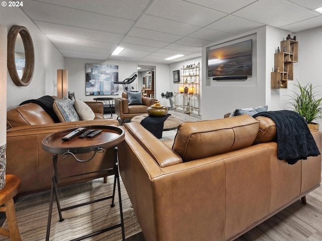 living room featuring a drop ceiling and light hardwood / wood-style floors