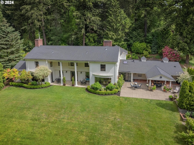 rear view of property featuring a lawn and a patio area