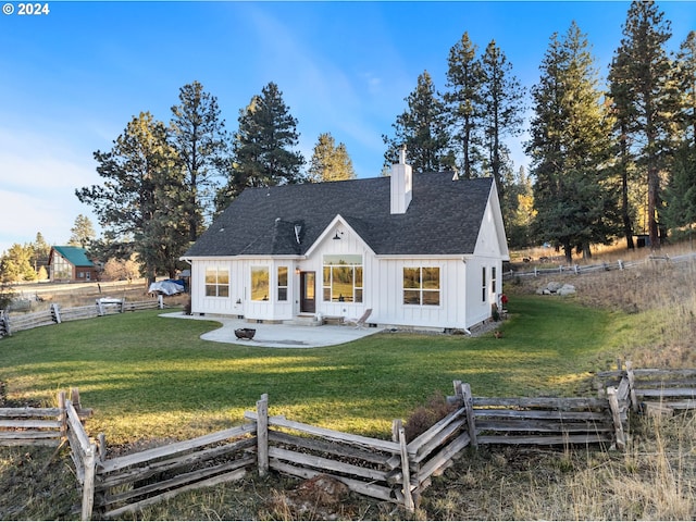 back of property featuring a yard, an outdoor fire pit, and a patio area