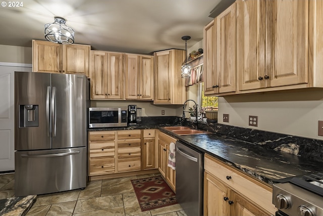 kitchen featuring light brown cabinets, decorative light fixtures, sink, dark stone countertops, and stainless steel appliances