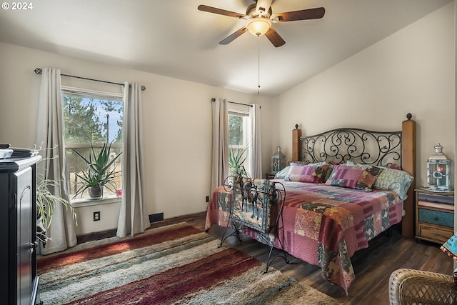 bedroom with ceiling fan, dark wood-type flooring, and lofted ceiling