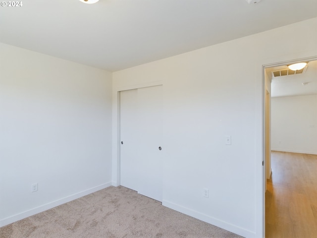 spare room featuring light colored carpet