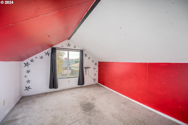 bonus room with light carpet and vaulted ceiling