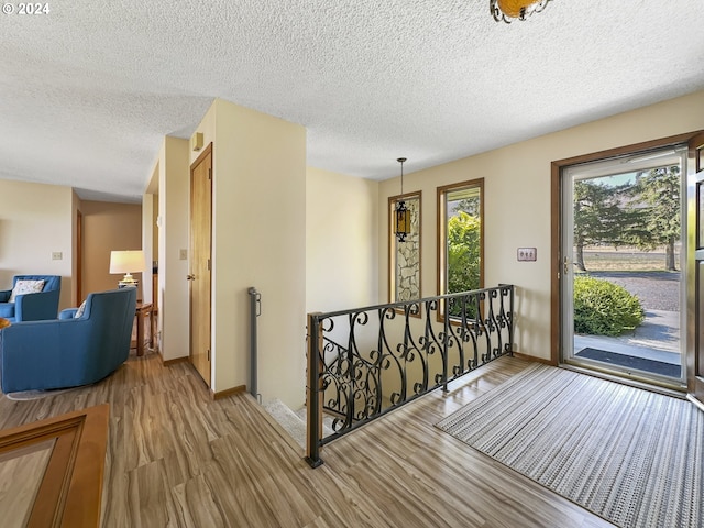 corridor with hardwood / wood-style floors and a textured ceiling