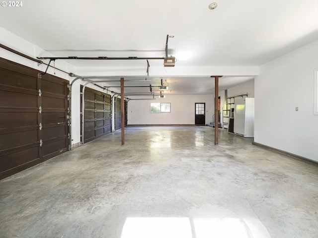 garage featuring white refrigerator and a garage door opener