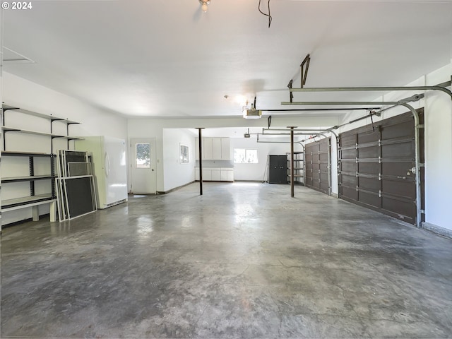 garage featuring a garage door opener and white refrigerator