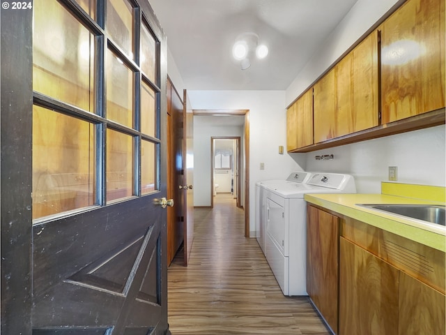 washroom with cabinets, washing machine and dryer, and wood-type flooring