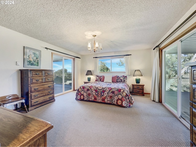 bedroom featuring access to exterior, a textured ceiling, an inviting chandelier, and carpet