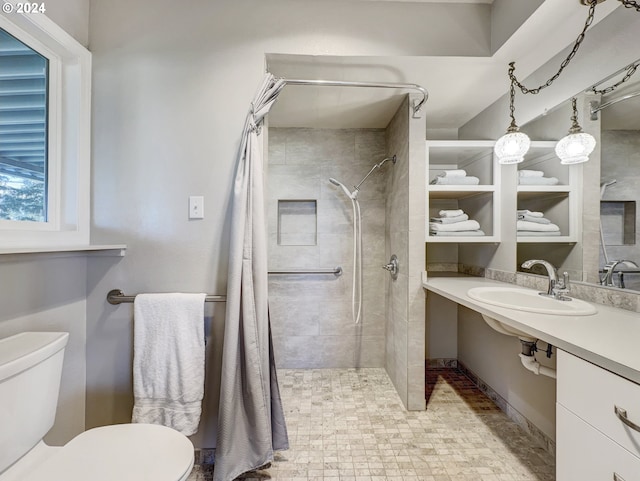 bathroom featuring toilet, sink, and a tile shower