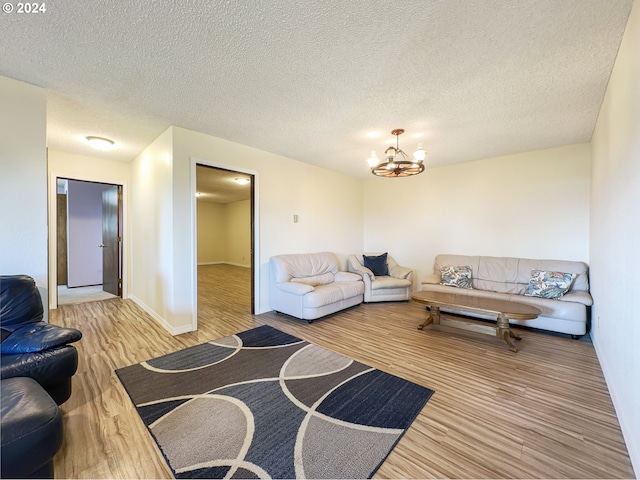 living room with hardwood / wood-style flooring, a textured ceiling, and a notable chandelier