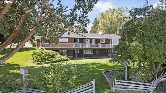 back of property with a balcony and a yard