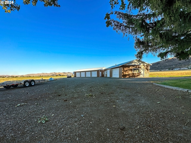 view of yard with a mountain view and a garage