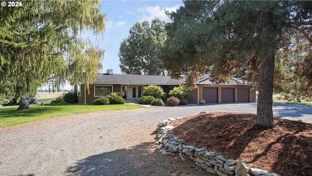 ranch-style home featuring a garage and a front yard