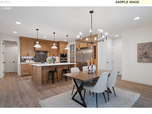 dining room featuring hardwood / wood-style floors, an inviting chandelier, and sink