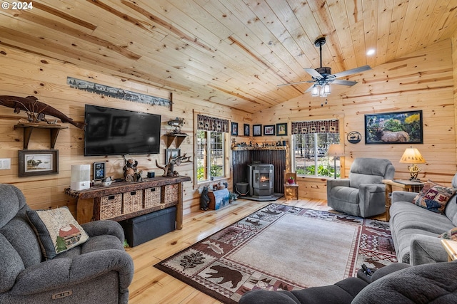 living room with wood-type flooring, a wood stove, wood walls, and wood ceiling