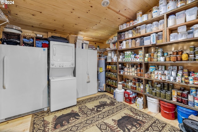 interior space featuring stacked washer / drying machine, light hardwood / wood-style floors, electric water heater, and wooden ceiling