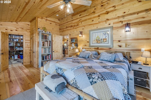 bedroom featuring wooden walls, light hardwood / wood-style flooring, lofted ceiling, and wood ceiling