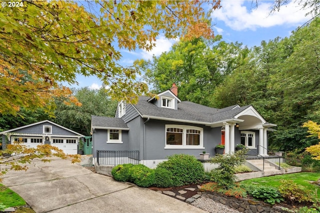 view of front of property featuring a garage and an outdoor structure