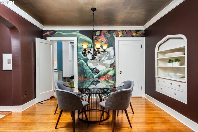 dining area featuring a notable chandelier, light wood-type flooring, and ornamental molding