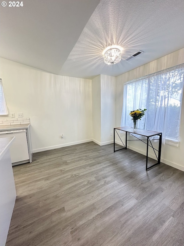 interior space with a textured ceiling, hardwood / wood-style flooring, and a chandelier