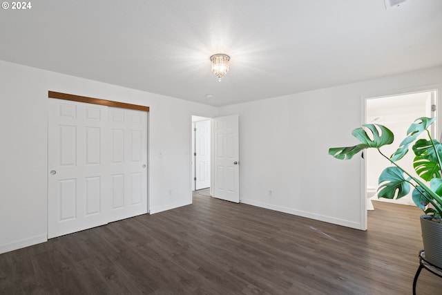 unfurnished bedroom with a closet and dark wood-type flooring