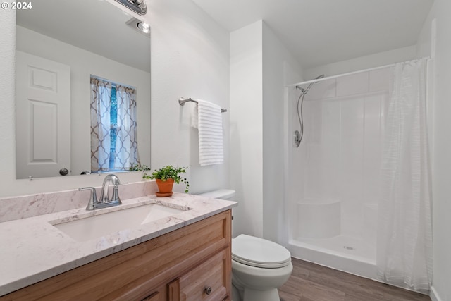 bathroom with vanity, hardwood / wood-style floors, toilet, and walk in shower