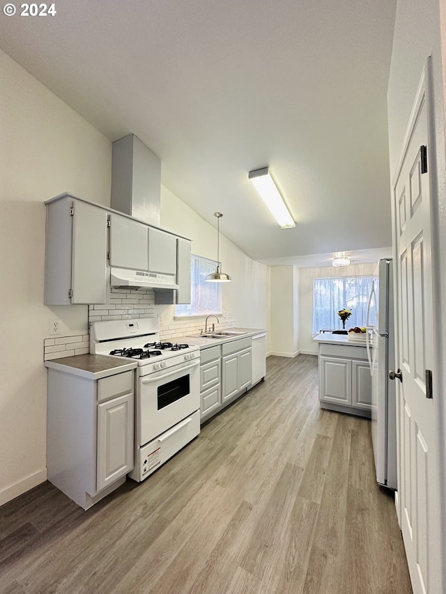 kitchen with light hardwood / wood-style flooring, backsplash, sink, decorative light fixtures, and white appliances