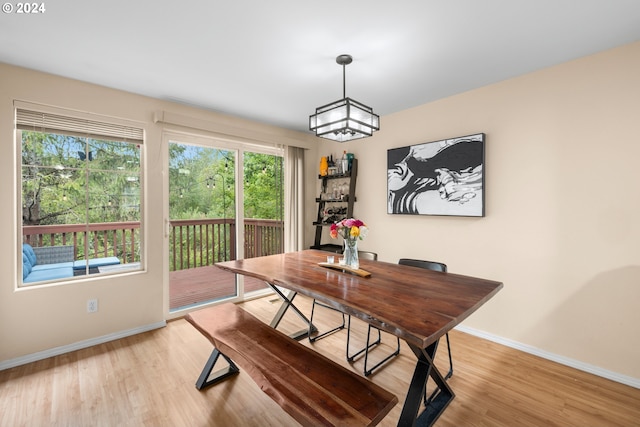 dining room with light wood-type flooring and a notable chandelier