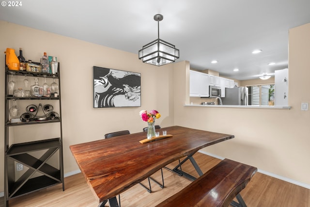 dining area featuring an inviting chandelier and light hardwood / wood-style flooring