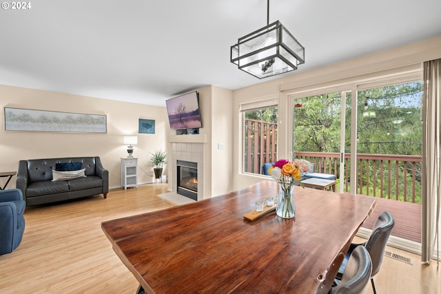 dining space featuring light wood-type flooring and a fireplace