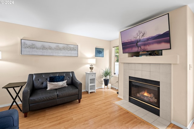 living room featuring light hardwood / wood-style flooring and a tile fireplace