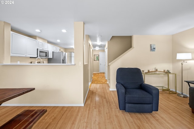 living area featuring light hardwood / wood-style floors and sink