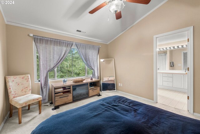 bedroom with ornamental molding, connected bathroom, and light colored carpet