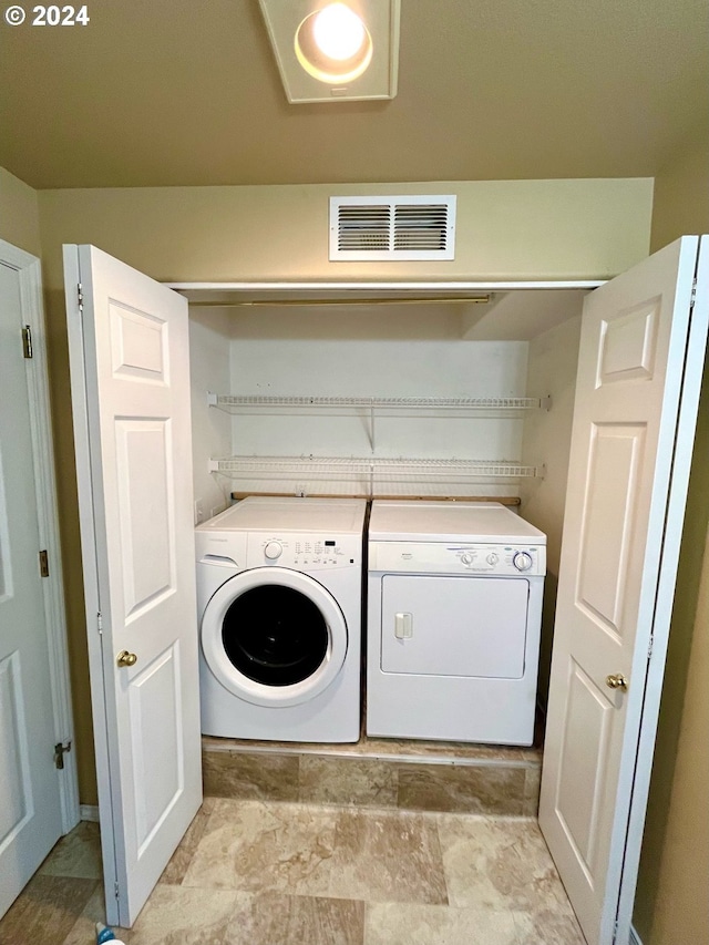 laundry room with light tile patterned floors and washer and clothes dryer