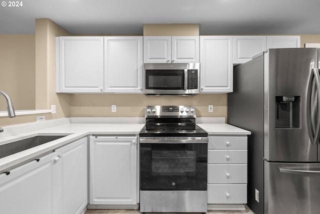 kitchen featuring white cabinets, stainless steel appliances, and sink