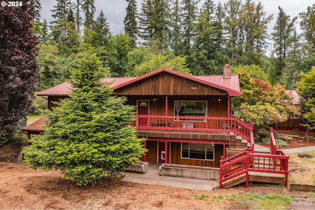 42681 Island Inn Dr, Lebanon, OR 97355 - rear view of house featuring a standing seam roof, metal roof, a chimney, and stairway