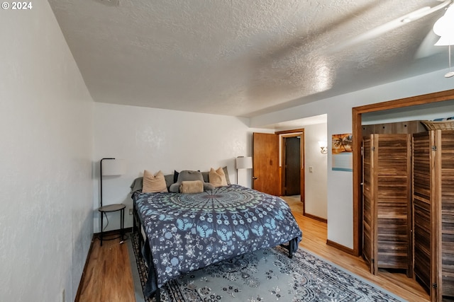 bedroom featuring a textured ceiling, light hardwood / wood-style flooring, and ceiling fan