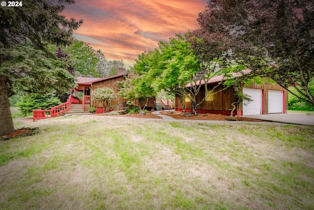 view of front of house featuring a garage and a lawn