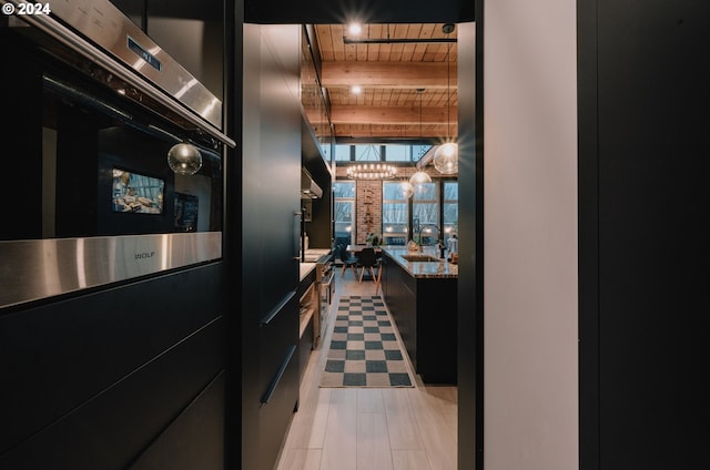 kitchen featuring beamed ceiling, light stone countertops, wooden ceiling, sink, and light tile floors