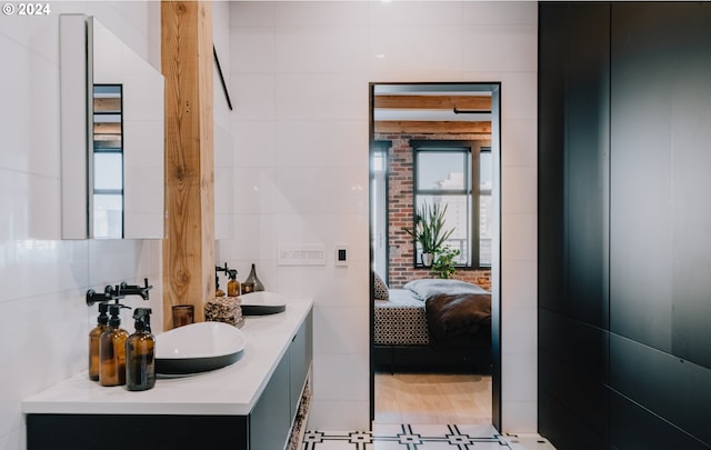 bathroom with tile floors, tile walls, and large vanity