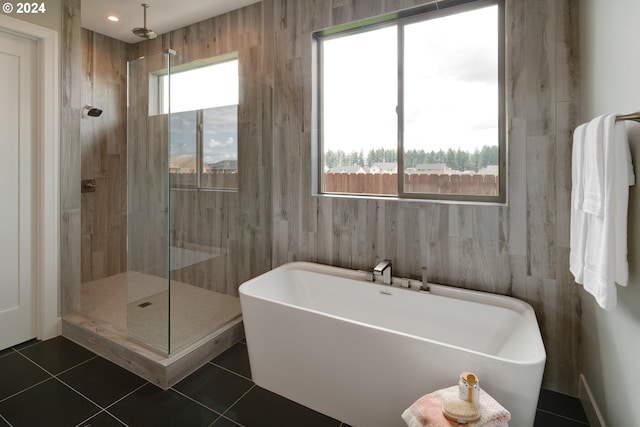 bathroom with wooden walls, tile flooring, and plus walk in shower