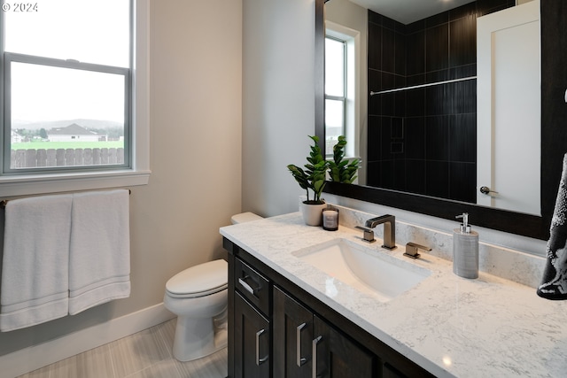 bathroom featuring tile flooring, vanity, and toilet