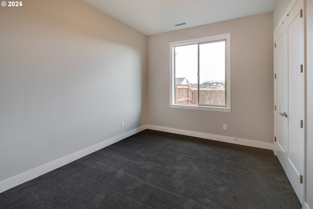 empty room featuring dark carpet