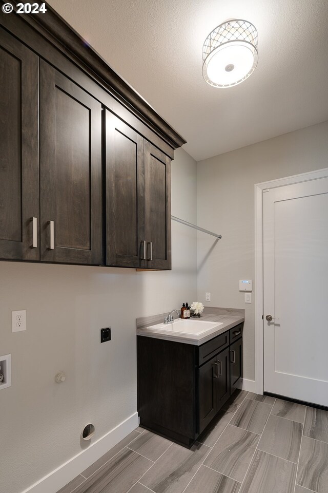 laundry room featuring hookup for a washing machine, sink, electric dryer hookup, and cabinets