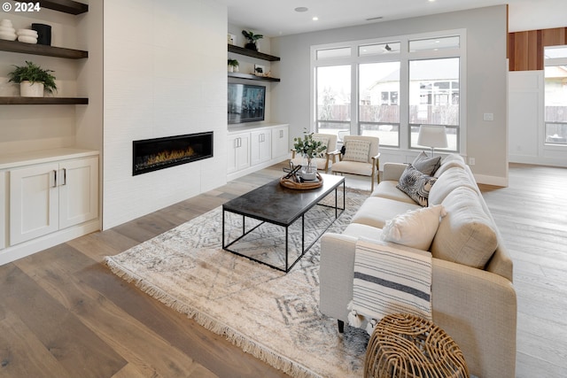 living room featuring light hardwood / wood-style flooring and a tile fireplace