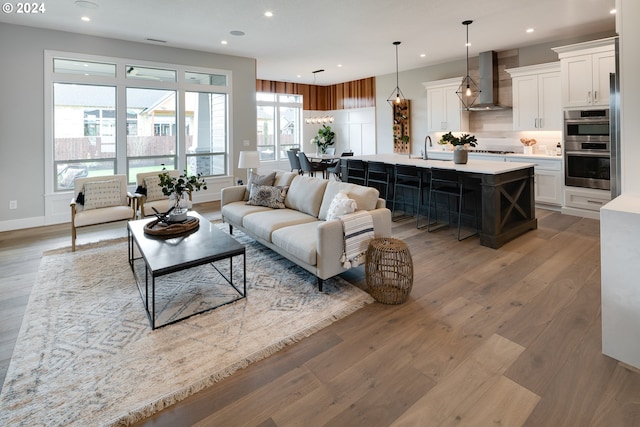 living room with plenty of natural light, sink, and wood-type flooring